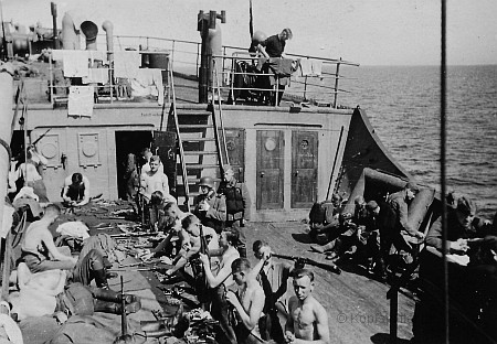 Soldaten auf einem Transportschiff beim Waffenreinigen im Jahr 1941